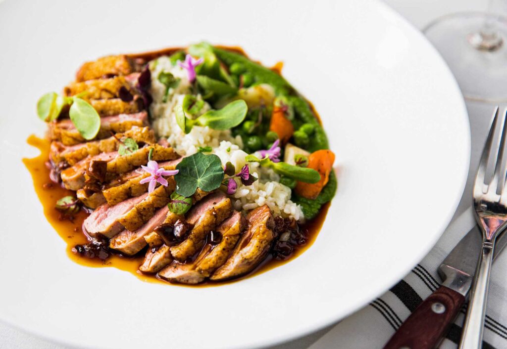 A plate of food that includes meat, rice, and vegetables
