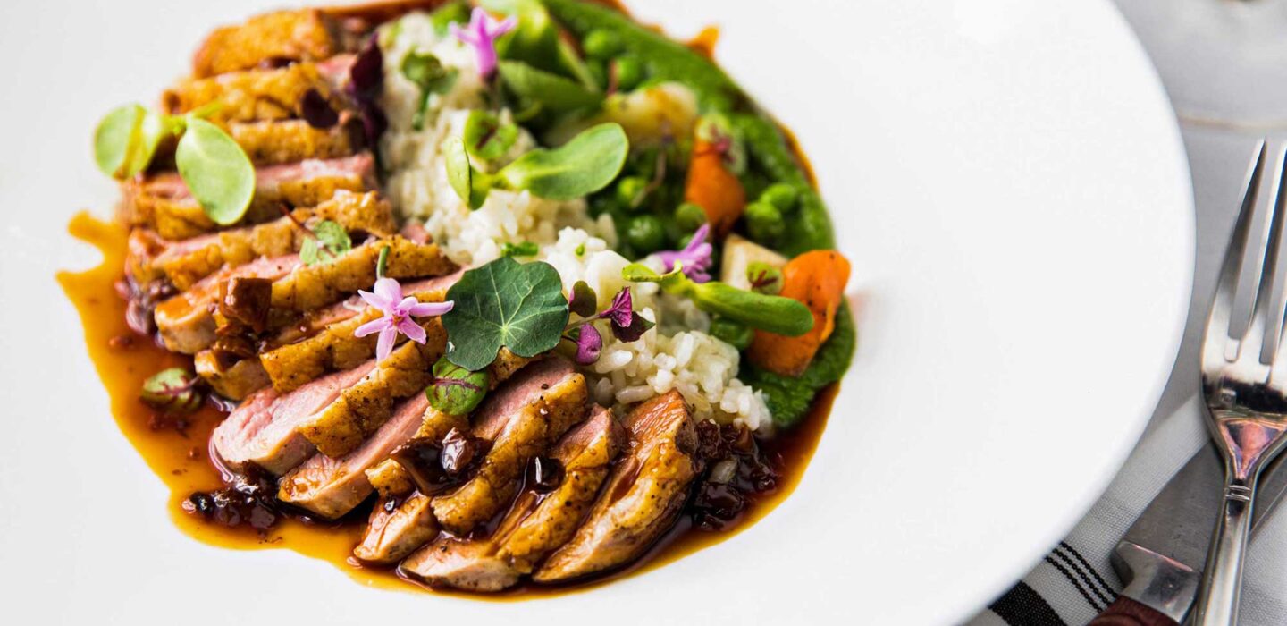 A plate of food that includes meat, rice, and vegetables