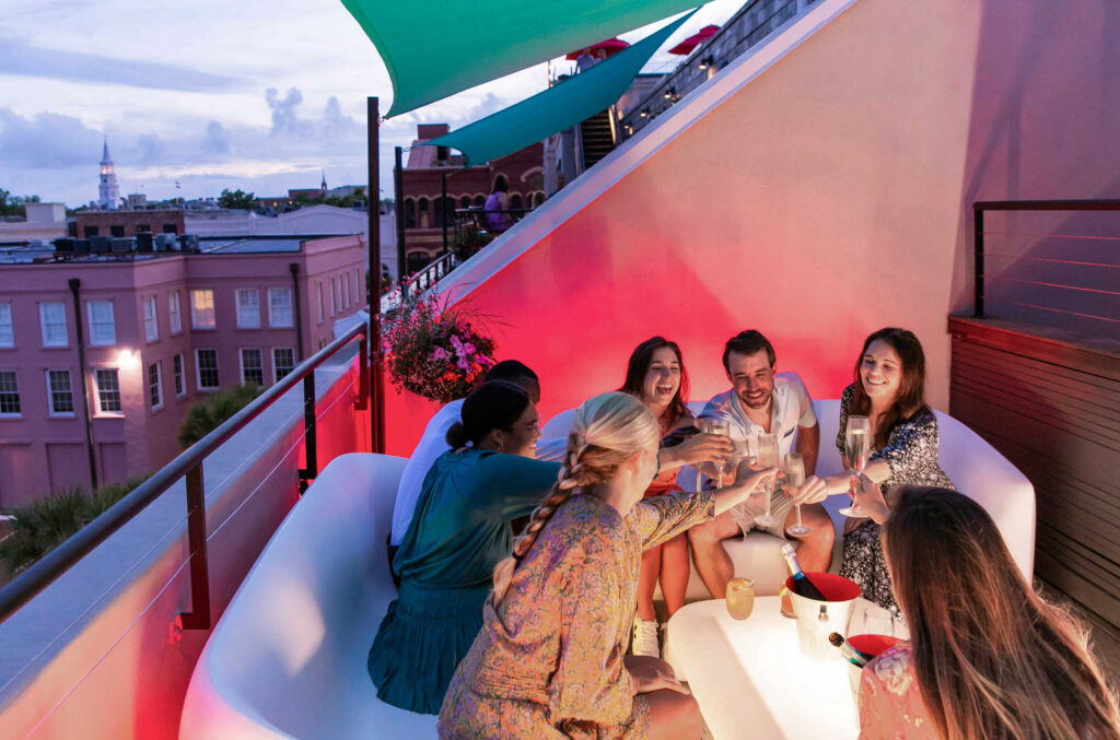 Group of friends toasting with champagne glasses at a rooftop bar