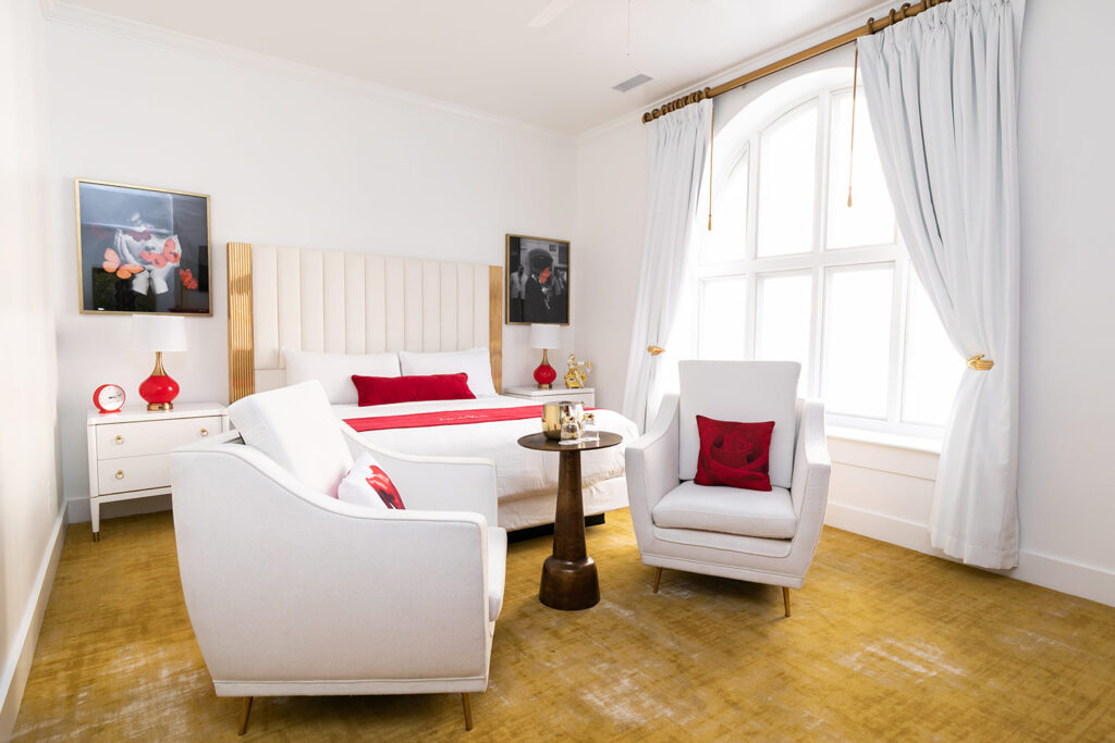 Hotel room with large window, king size bed, and two chairs