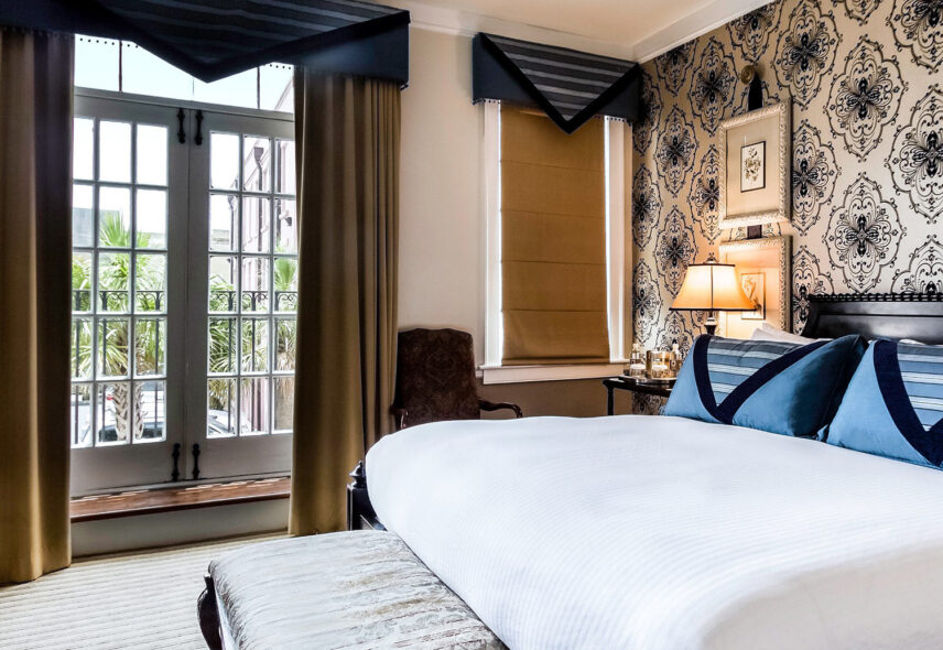 Hotel room with a view and a king bed and patterned wallpaper