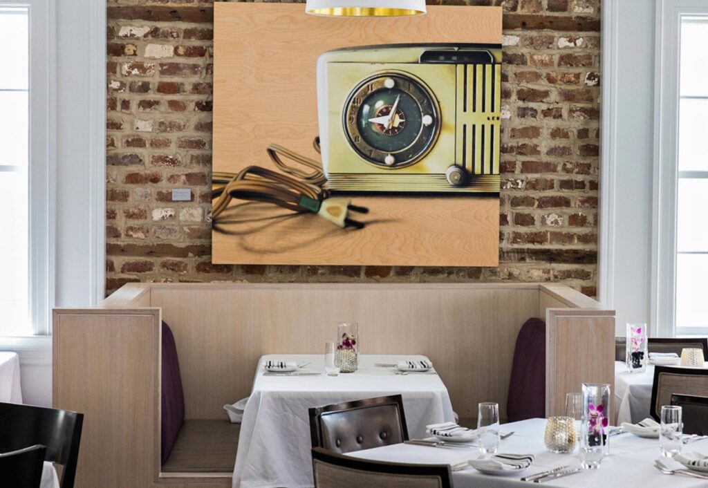 Table booth at a restaurant underneath a picture of an old radio clock