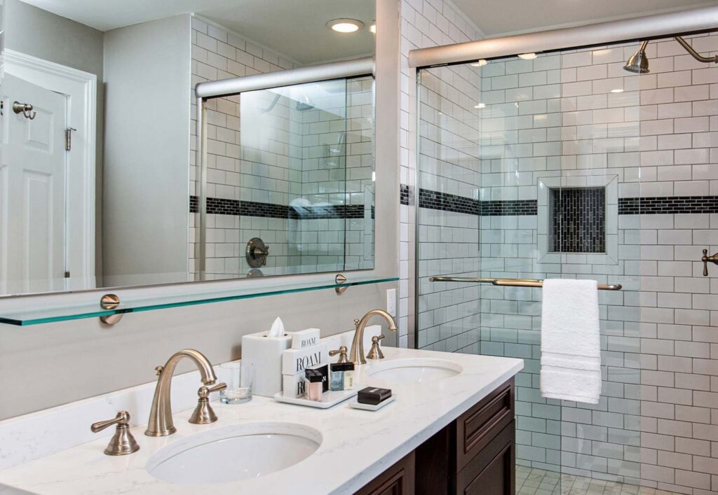 Hotel room bathroom with dual sinks and walk in shower