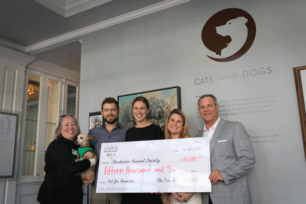 a group of people holding a novelty-size donation check for a donation to an animal society