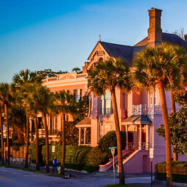 a pink house with palm trees in front of it